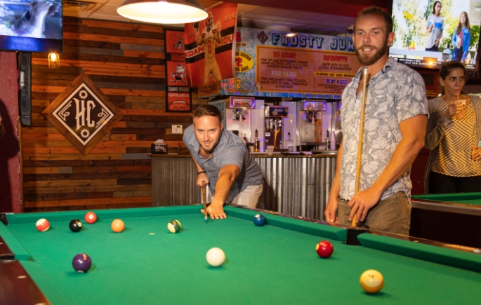 Guys playing pool in bar setting